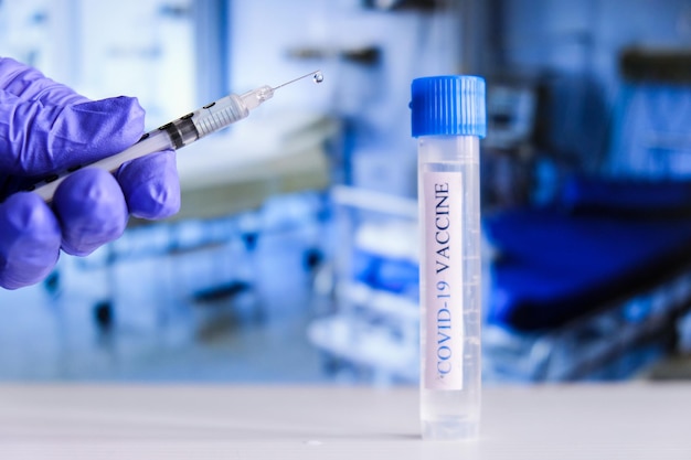 Le médecin tient une seringue avec le vaccin Ampoules Covid-19 sur un banc de laboratoire. Combattez le coronavirus, la pandémie de sras-cov-2. Notion de coronavirus 2019-nCoV COVID. Vaccination