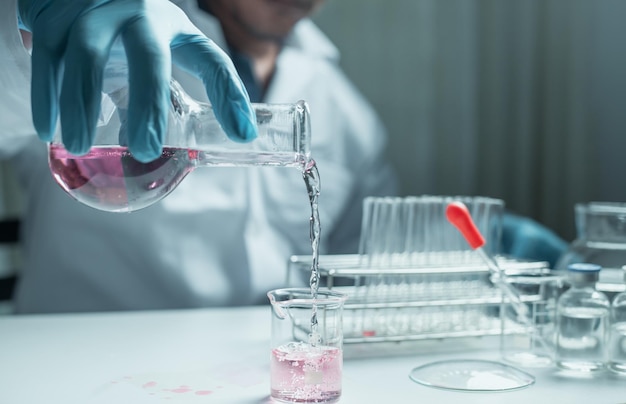 Photo le médecin tient un tube à essai dans le support test vasculaire avec expérience de recherche d'échantillons de sang