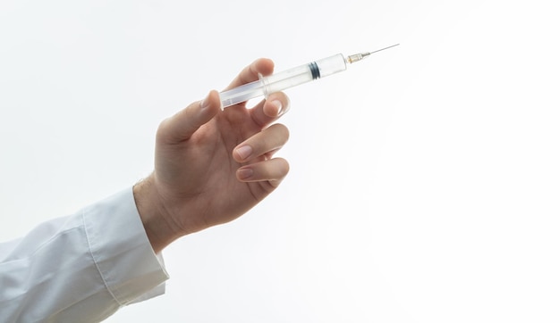 Médecin en train d'injecter un médicament avec une seringue isolée contre un fond blanc en gros plan