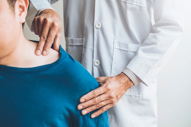 Médecin traitant en consultation avec un patient sur les problèmes de douleur à l&#39;épaule, aux muscles, à la physiothérapie, concept de diagnostic