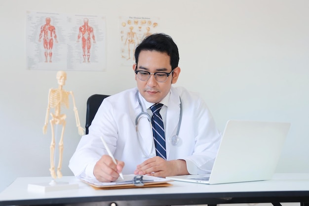 Médecin travaillant sur un ordinateur portable au bureau de la clinique.