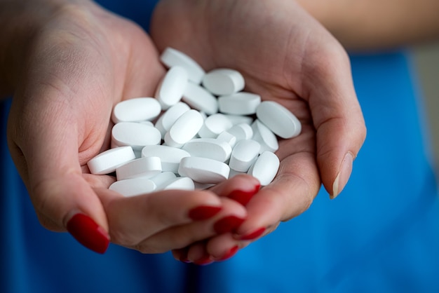 Médecin en uniforme bleu avec de nombreuses pilules blanches dans ses mains. 2019-nCoV