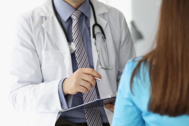 Un médecin en uniforme et un stéthoscope consultent une patiente