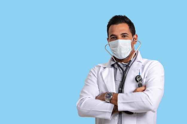 médecin en uniforme et stéthoscope, regarde la caméra, fond bleu