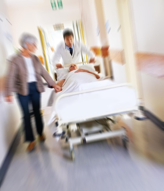 Médecin d'urgence et patient d'urgence aux soins médicaux à l'hôpital vieille femme et tenant la main pour l'amour Médecin de soins de santé urgents et mouvement pour le médicament ou le traitement médecin poussant et le confort de l'homme