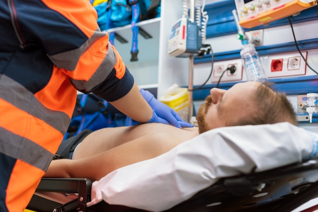 Un médecin urgentiste réanime un patient en ambulance. Réanimation RCP.