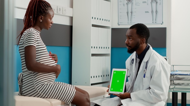 Photo médecin utilisant un affichage à écran vert sur une tablette numérique lors du contrôle