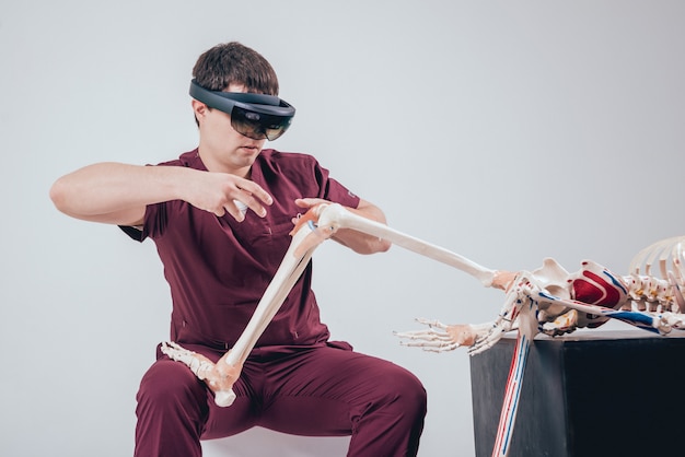 Un médecin utilise des lunettes de réalité augmentée pour examiner le squelette humain