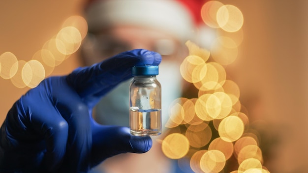 Médecin avec vaccin sur fond de Noël