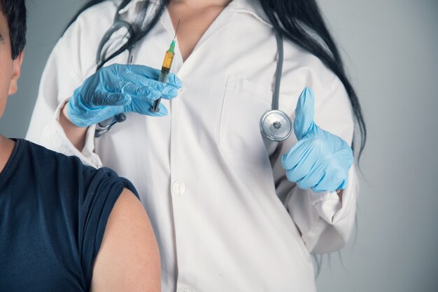 Un médecin vaccine un jeune