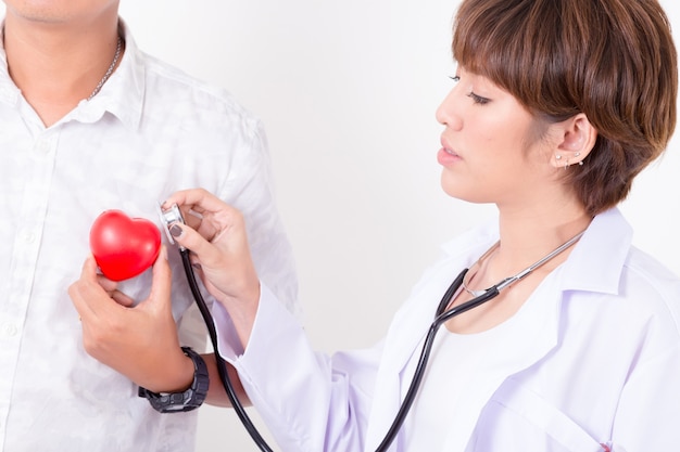 Médecin vérifiant le coeur rouge avec la ligne ecg et stéthoscope.