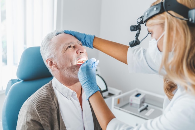 Médecin vérifiant la gorge de l'homme avec un bâton médical