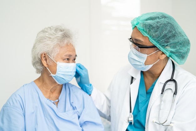 Médecin vérifiant une patiente âgée asiatique portant un masque facial à l'hôpital pour protéger le coronavirus Covid19