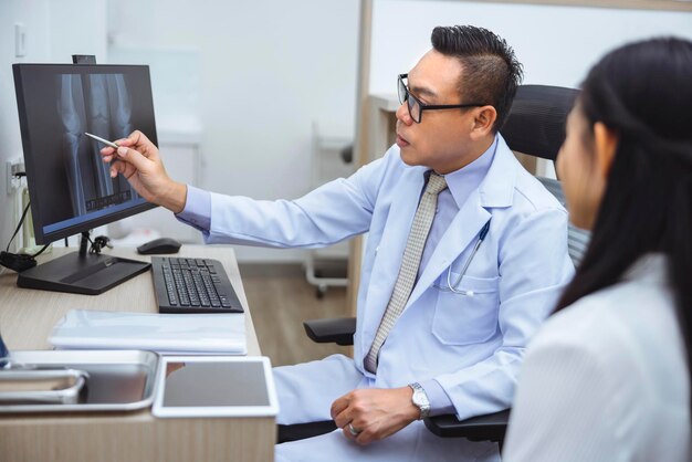 Le médecin vérifie les os des articulations du patient sur l'écran d'ordinateur de la clinique