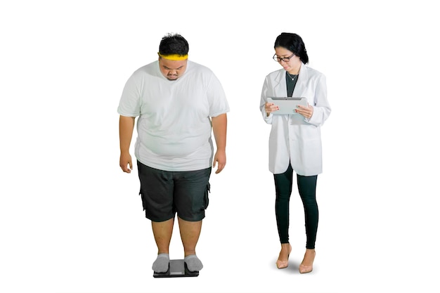 Le médecin vérifie le poids de son gros patient avec une balance