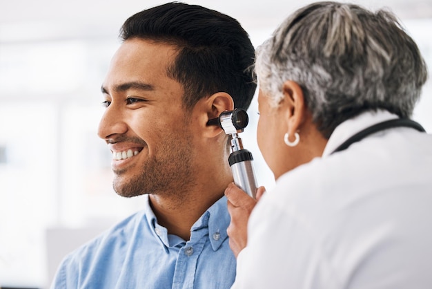 Médecin vérifie les soins de santé de l'oreille du patient et la consultation médicale à l'hôpital avec un spécialiste en oto-rhino-laryngologie Heureux homme et médecin femme avec test otoscope pour problème d'audition et assurance maladie