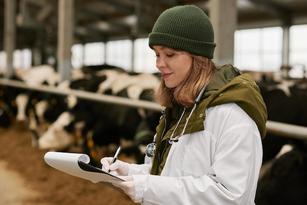 Médecin vétérinaire prenant des notes sur la carte sur les animaux