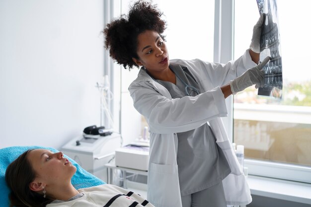 Photo médecin de vue de côté expliquant la radiographie