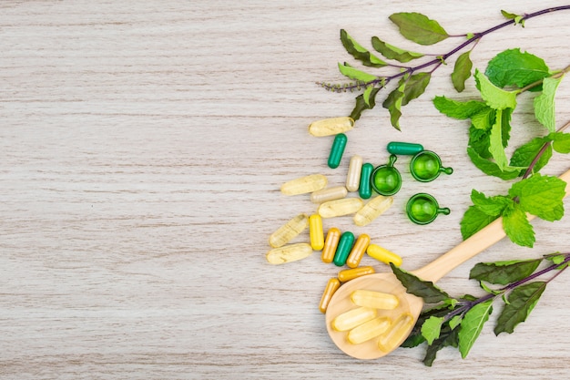 Médecine alternative à base de plantes en capsules sur une table en bois avec espace de copie