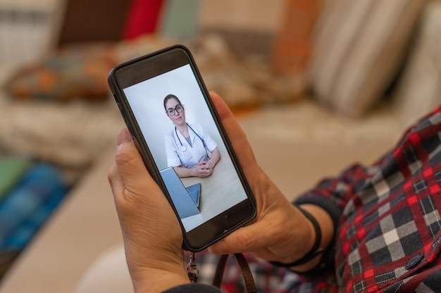 Médecine en ligne en quarantaine Une vieille femme présentant des symptômes de coronavirus parle en appel vidéo avec un virologue Un retraité mesure la température Consultation à distance du médecin par téléphone