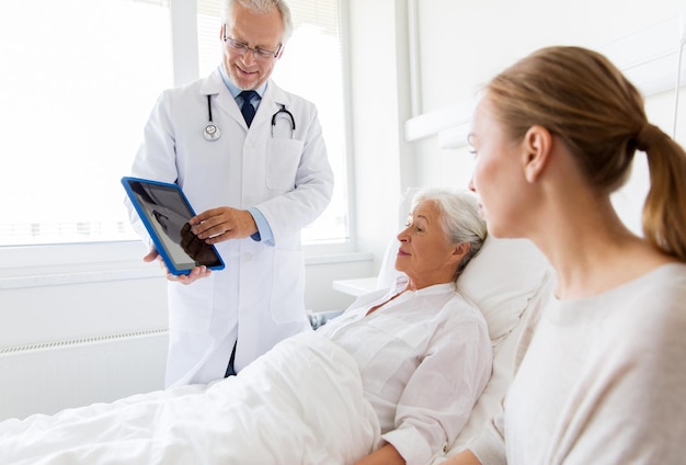 Photo médecine soins de santé et concept de personnes femme âgée patient avec fille et médecin avec tablette pc ordinateur dans le service de l'hôpital