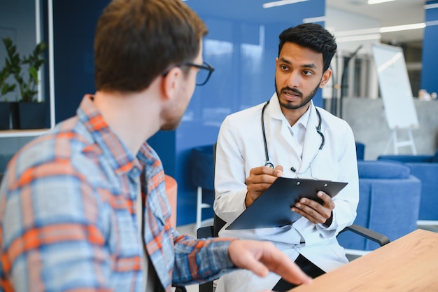 Médecine soins de santé et concept de personnes médecin indien jeune patient de sexe masculin réunion à l'hôpital