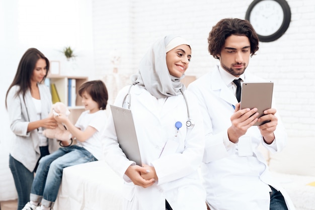 Les médecins arabes regardent quelque chose sur la tablette.