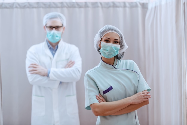 Médecins debout, les bras croisés à l'hôpital.