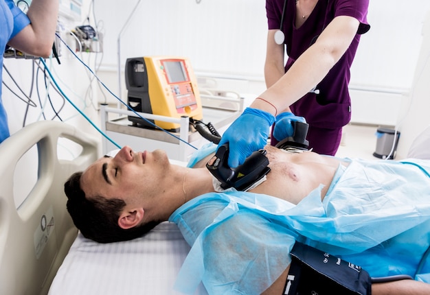 Les médecins donnent la réanimation à un patient de sexe masculin dans la salle d'urgence.