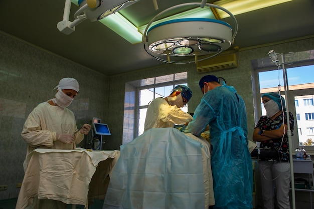 Photo les médecins effectuent une opération dans la salle d'opération