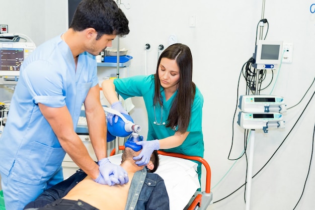 Médecins faisant une procédure d'urgence avec respirateur