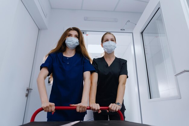 Les médecins font rouler un lit d'hôpital vide dans le couloir