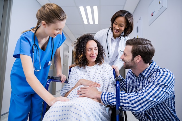 Médecins et homme réconfortant femme enceinte dans le couloir