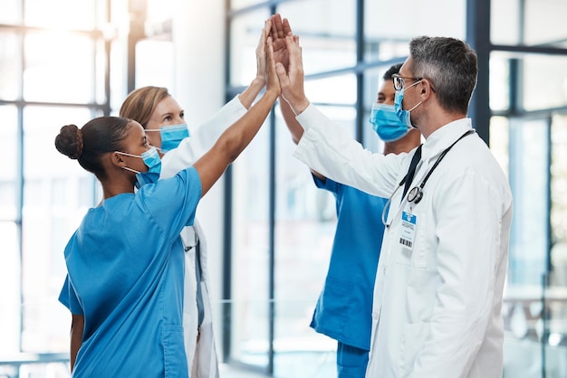 Médecins et infirmières de Covid high five pour le succès du travail d'équipe collaboration et soutien dans un hôpital motivation des professionnels de la santé et de la santé unité et communauté prêtes à travailler ensemble en équipe