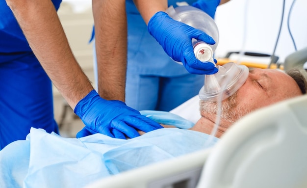 Médecins mettant un masque à oxygène sur un patient à l'hôpital Aide aux premiers secours Salle de réanimation Patient incontrôlable