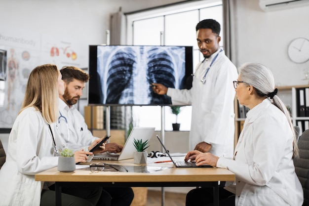 Médecins multiraciaux ayant une réunion sur le diagnostic du patient