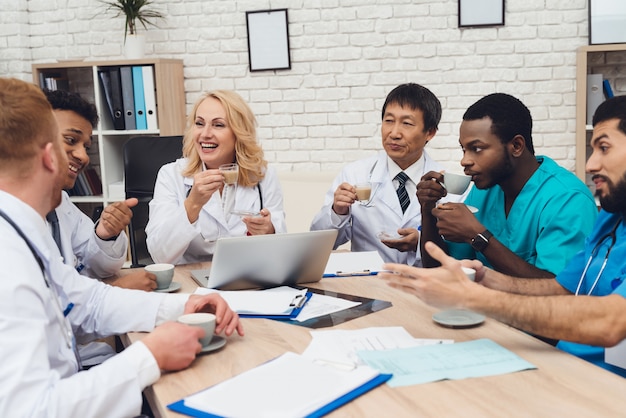 Les médecins ont des tasses de thé et de café entre les mains.