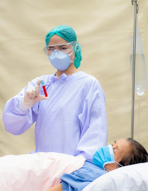 Les médecins portaient un masque, des lunettes, des mains tenant un tube pour collecter des échantillons de sang afin d'analyser la cause des patients âgés.