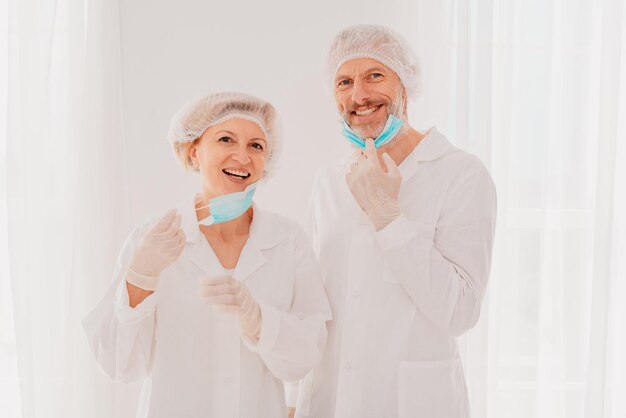 Des médecins souriants avec un masque facial sont heureux de travailler contre covid19