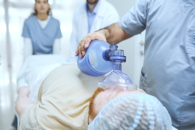 Des médecins en uniforme réanimant un patient avec un défibrillateur en urgence