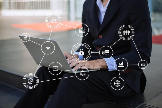 Médias de marketing numérique sur écran virtuel femme d'affaires travaillant à la main avec un téléphone portable et un ordinateur moderne avec un diagramme d'icônes VR au bureau