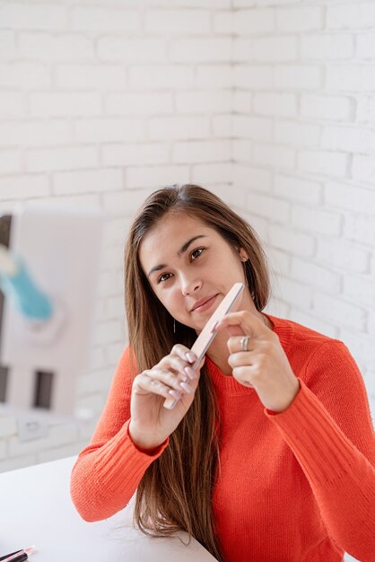 Des médias sociaux. Bloguer. Influenceur maître des ongles ayant un chat vidéo ou créant un blog