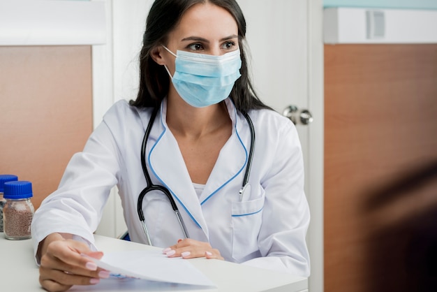 Photo medic en masque avec des papiers