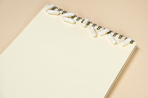 Photo medical notepad with pills on a beige background space for text
