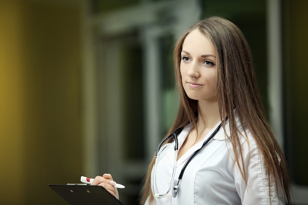 Médicament. Un beau sourire d'un docteur en tenue médicale. Un jeune docteur. Étudiant diplomé. Le médecin de famille est une femme. En robe blanche à l'hôpital.