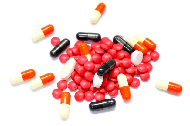 Médicament pilule rouge et capsule sur fond blanc