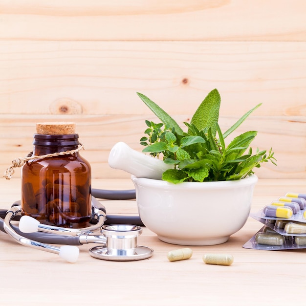 Photo des médicaments avec des herbes et un stéthoscope sur une table en bois