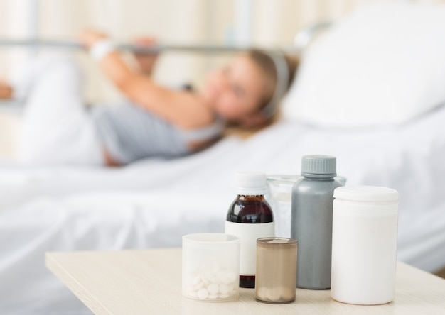 Médicaments sur la table avec une fille à l&#39;hôpital