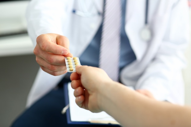Medico donnant des pilules au patient