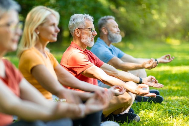 Photo méditation de groupe diverses personnes âgées sportives méditant ensemble à l'extérieur